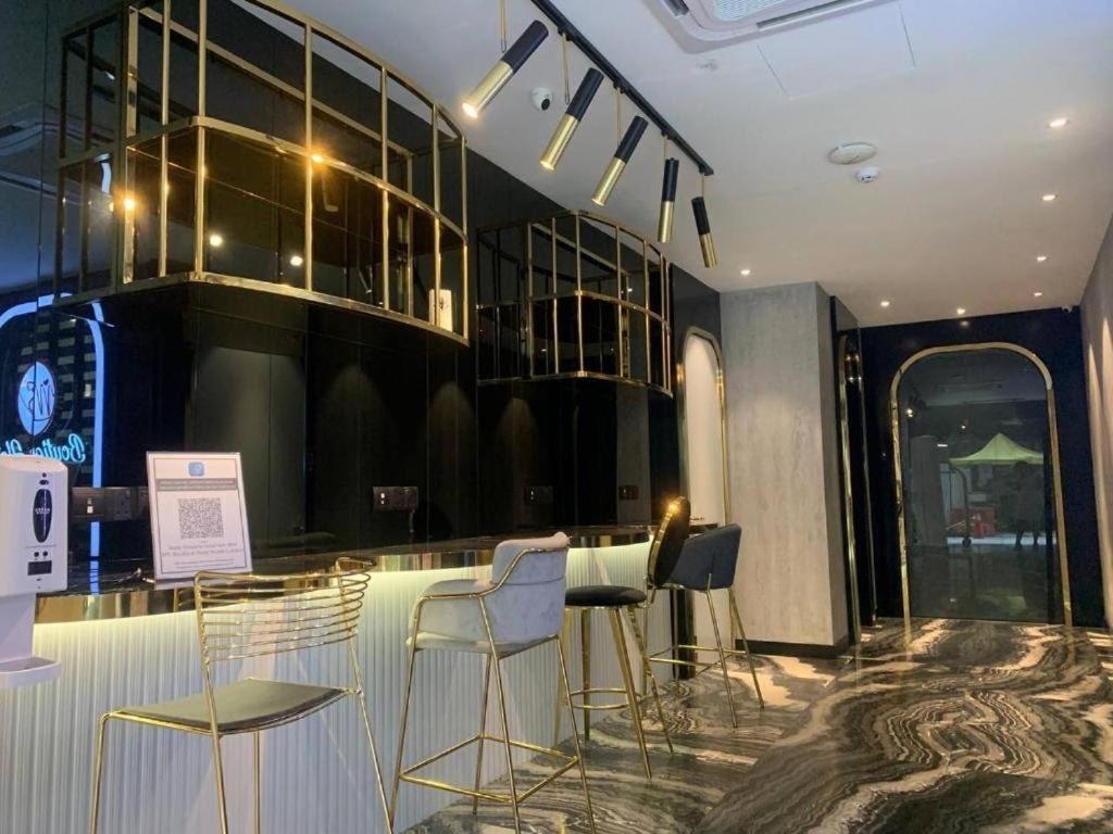 um bar com cadeiras e uma mesa num quarto em MS Hotel Kuala Lumpur em Kuala Lumpur