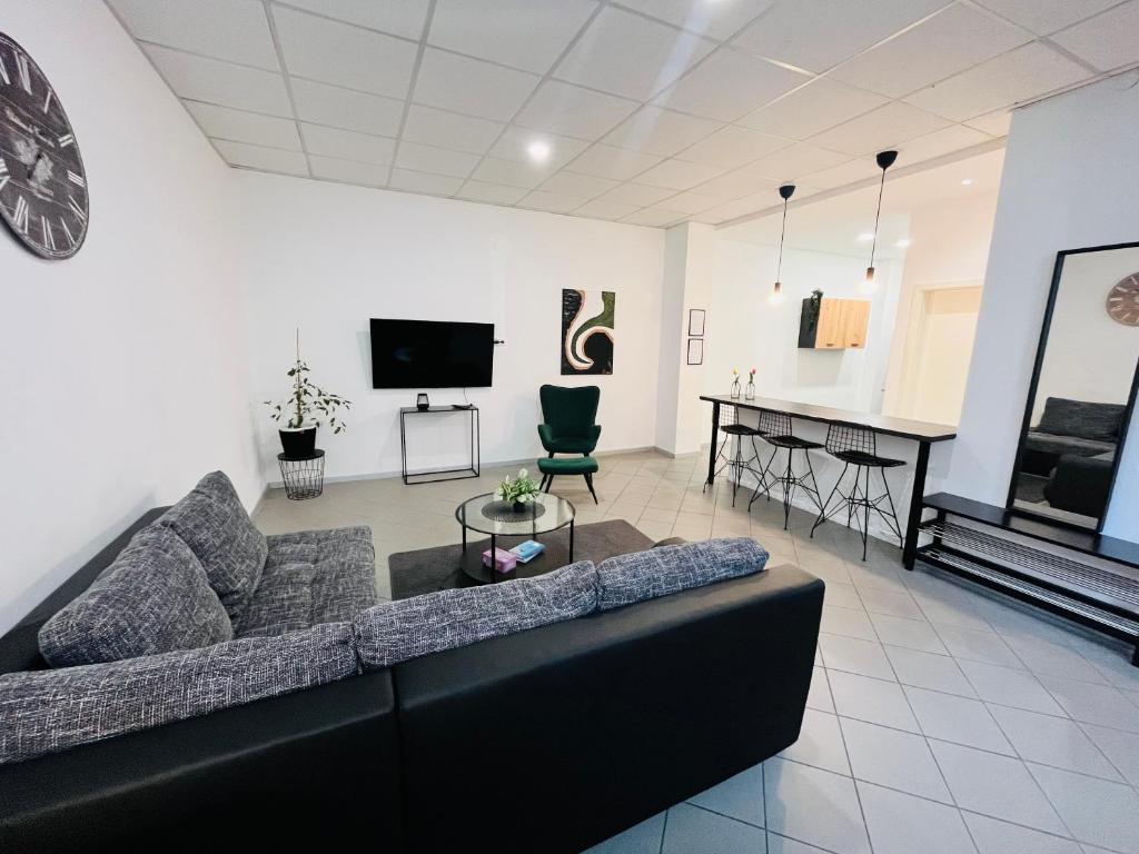 sala de estar con sofá negro y piano en Apartment Central 10D 55qm Wi-Fi free Parking calm back house, en Dortmund