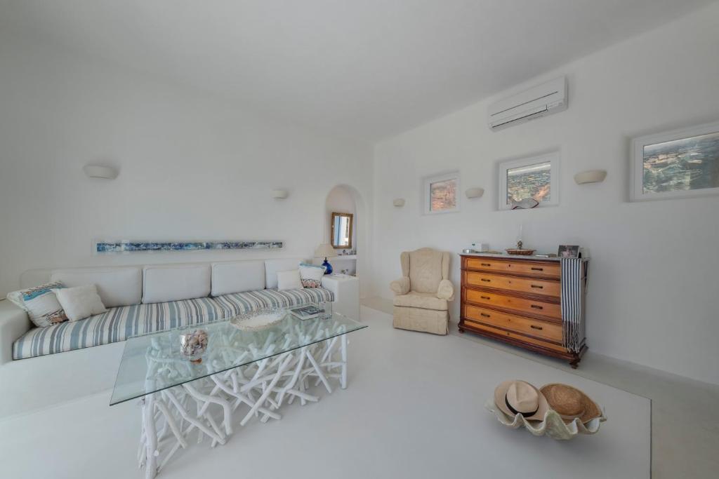 a living room with a couch and a glass table at VILLA AGAPI KYTHNOS in Agios Dimitrios