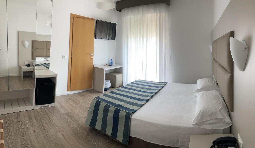 リド・ディ・イエゾロにあるHotel Sirenettaのベッドとバスルーム付きのホテルルームです。