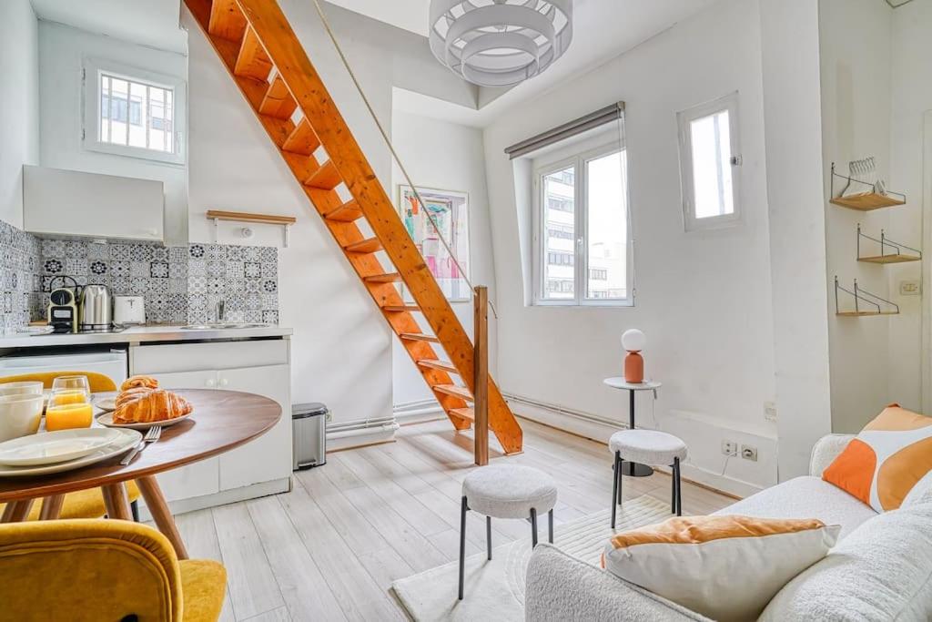 Il comprend une cuisine et un salon avec un escalier en colimaçon. dans l'établissement Studio proche Mairie du 14e arrondissement - III, à Paris