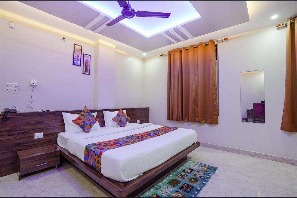 a bedroom with a bed and a ceiling fan at FabHotel Nandini Grand in Varanasi