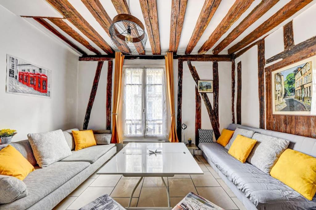 un salon avec un canapé et une table dans l'établissement Appartement charmant, atypique et central !, à Paris