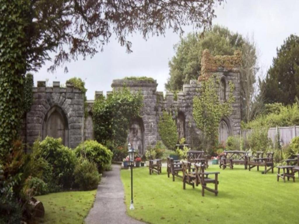 a stone building with tables and benches in a park at Pass the Keys Luxury Apartment Ulverston 6 in Ulverston