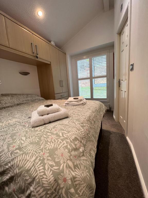 a bedroom with a large bed with towels on it at Throstles Nest in Troutbeck Bridge