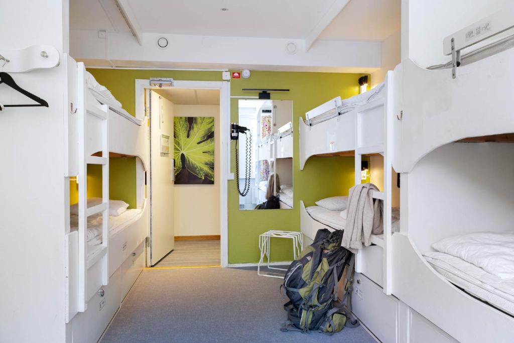 Habitación con literas blancas y pasillo. en Backpackers Göteborg, en Gotemburgo
