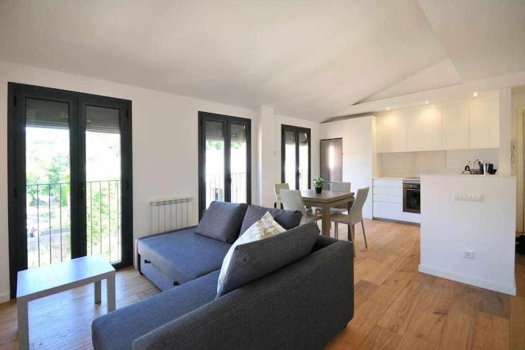 sala de estar con sofá azul y mesa en Stunning apartment w amazing views and aircon, en Girona