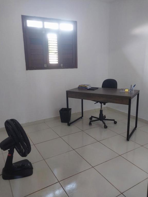 an office with a desk and a chair in a room at Casa Aconchegante em Areia in Areia