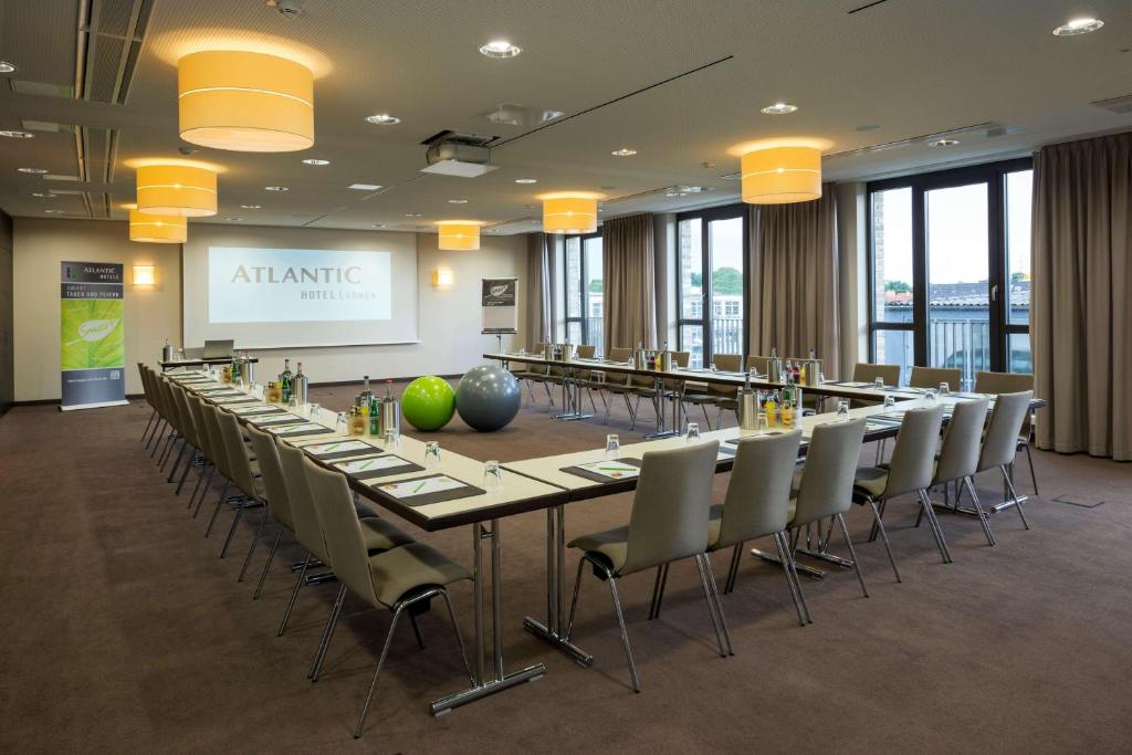 a large conference room with a long table and chairs at ATLANTIC Hotel Lübeck in Lübeck