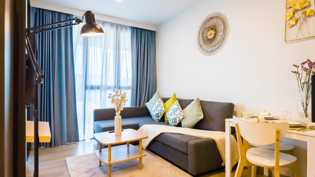 ein Wohnzimmer mit einem Sofa und einem Tisch in der Unterkunft Уютные апартаменты в Laguna Skypark in Phuket