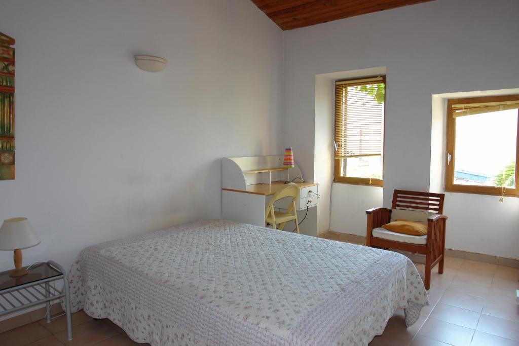 1 dormitorio con cama, escritorio y silla en Chambre dans maison de caractère, en Nimes