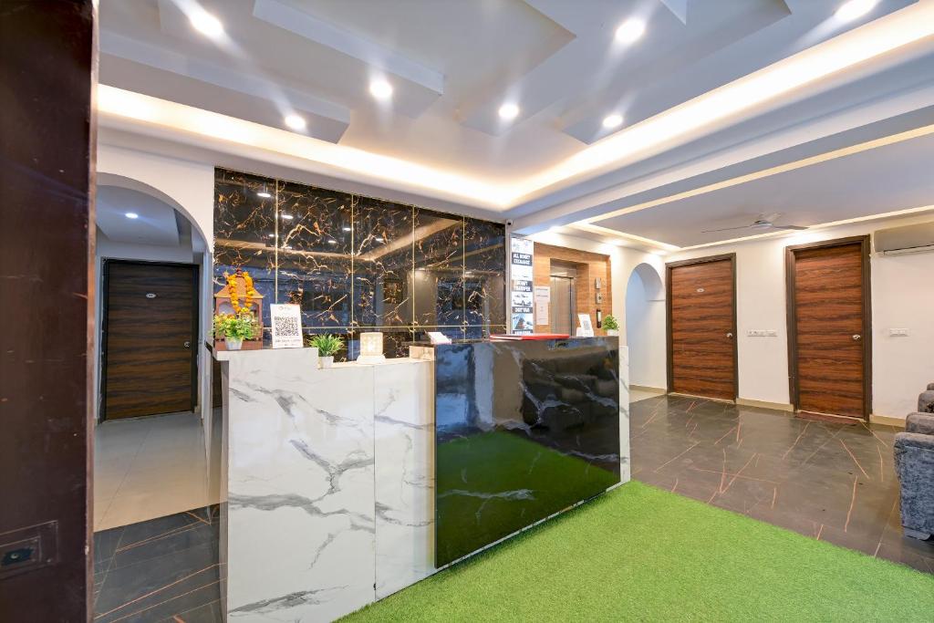 a lobby with a marble counter and a green carpet at Grand Empire Suites By Delhi Airport in New Delhi