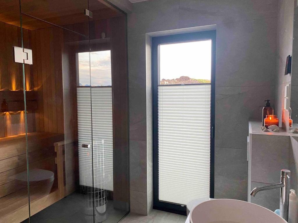 a bathroom with two windows and a sink and a toilet at New lodge at seaside, near Henningsvær Lofoten in Kleppstad