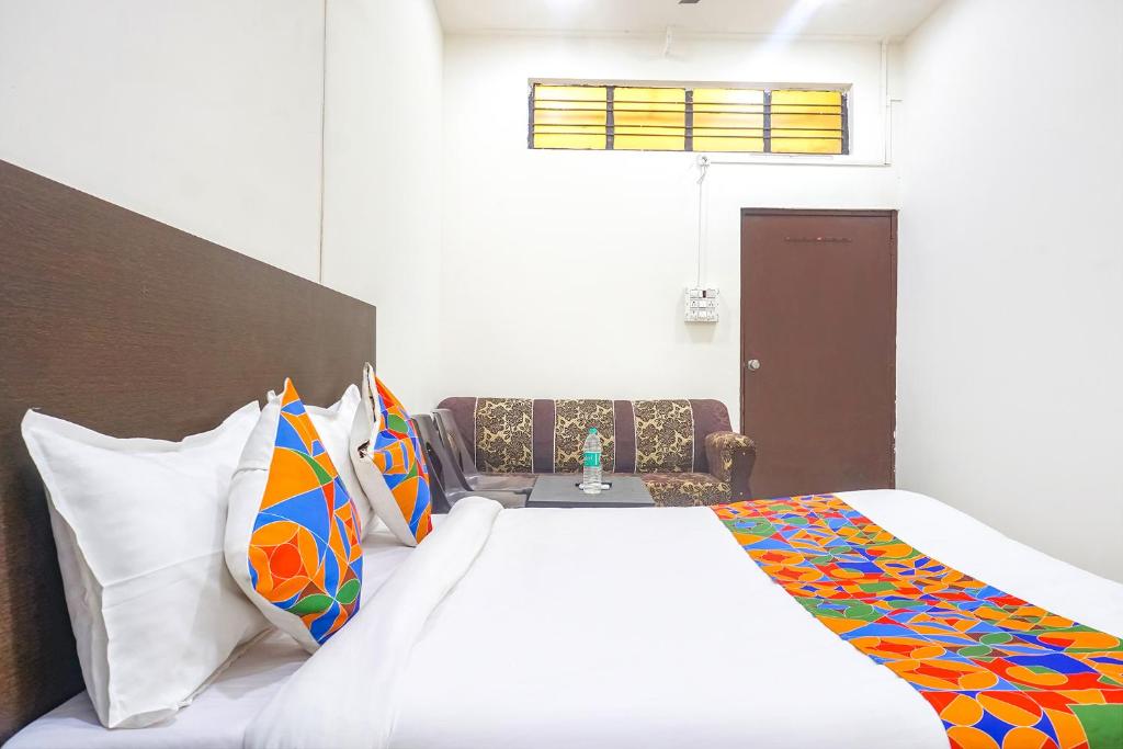 Postel nebo postele na pokoji v ubytování FabHotel Om Sai - Nr Nashik Railway Station