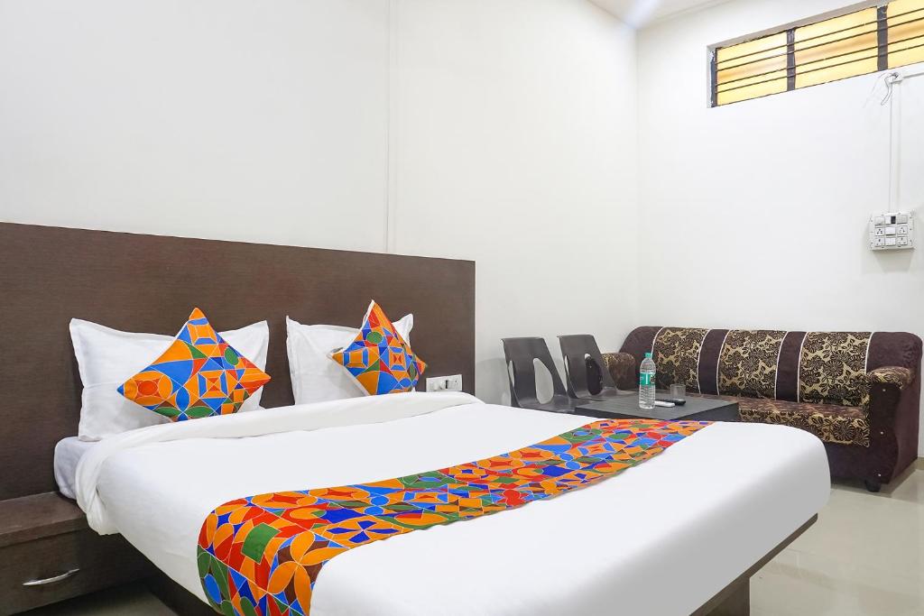 Postel nebo postele na pokoji v ubytování FabHotel Om Sai - Nr Nashik Railway Station