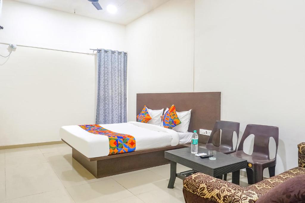 Postel nebo postele na pokoji v ubytování FabHotel Om Sai - Nr Nashik Railway Station