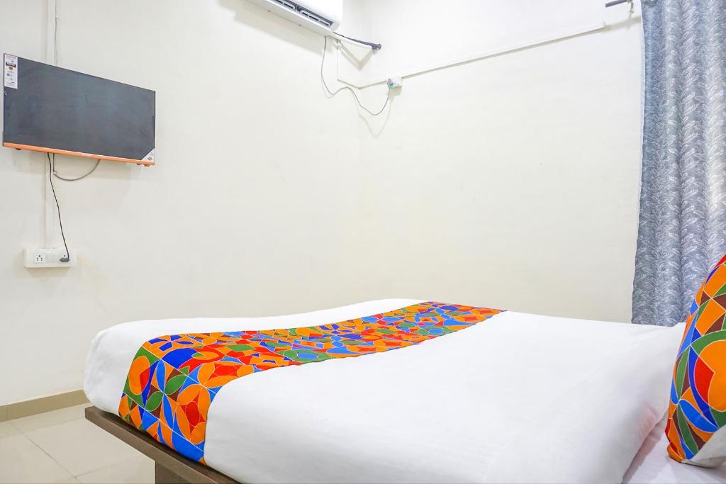 Postel nebo postele na pokoji v ubytování FabHotel Om Sai - Nr Nashik Railway Station