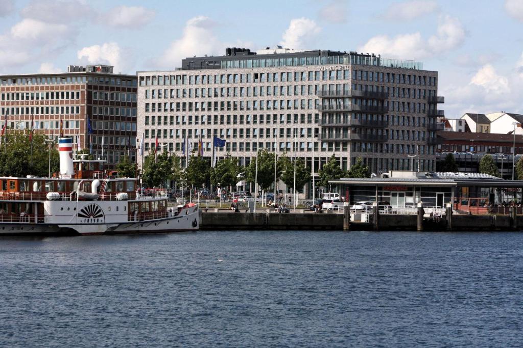 a boat is docked at a dock in a city at Atlantic Hotel Kiel in Kiel