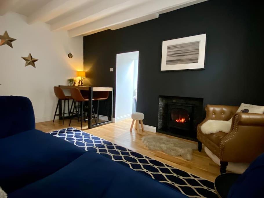 a living room with a bed and a fireplace at Clover Neuk Mews Cottage, 34a Main Road in Fairlie