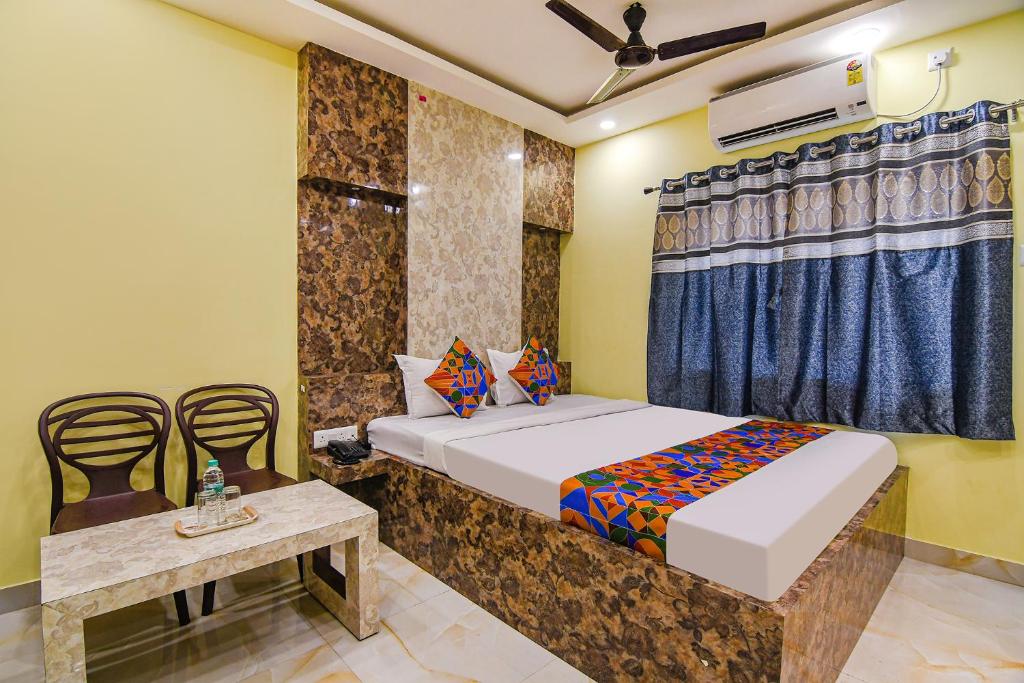 1 dormitorio con 1 cama, mesa y sillas en FabHotel Divine Chariot en Calcuta