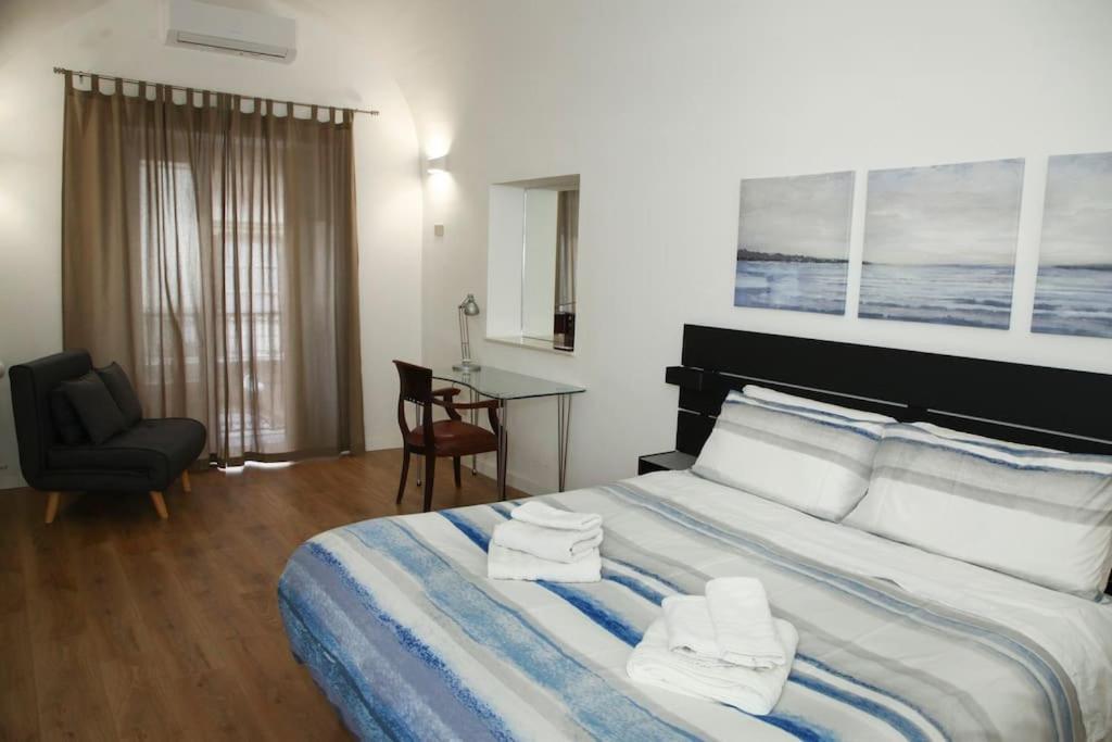 a bedroom with a bed and a chair and a desk at Quattro Canti - residenza Santa Caterina in Palermo