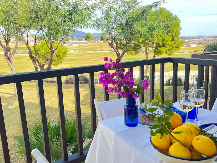 una mesa con un bol de fruta y flores en el balcón en Inmejorable Aptmto. vistas directas golf El Valle Golf, en Baños y Mendigo