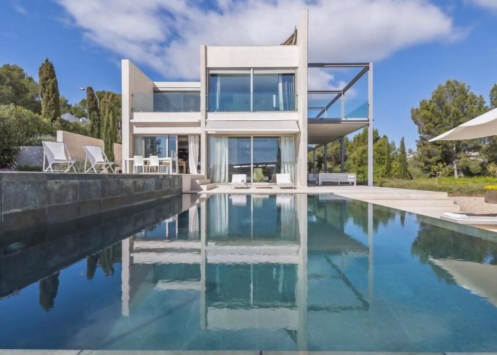 a house with a swimming pool in front of it at Olivo - Sol de Mallorca in Sol de Mallorca