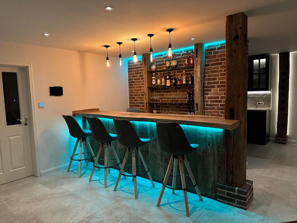 a bar with black stools in a room at Ferienwohnung Rettbrook in Bad Zwischenahn