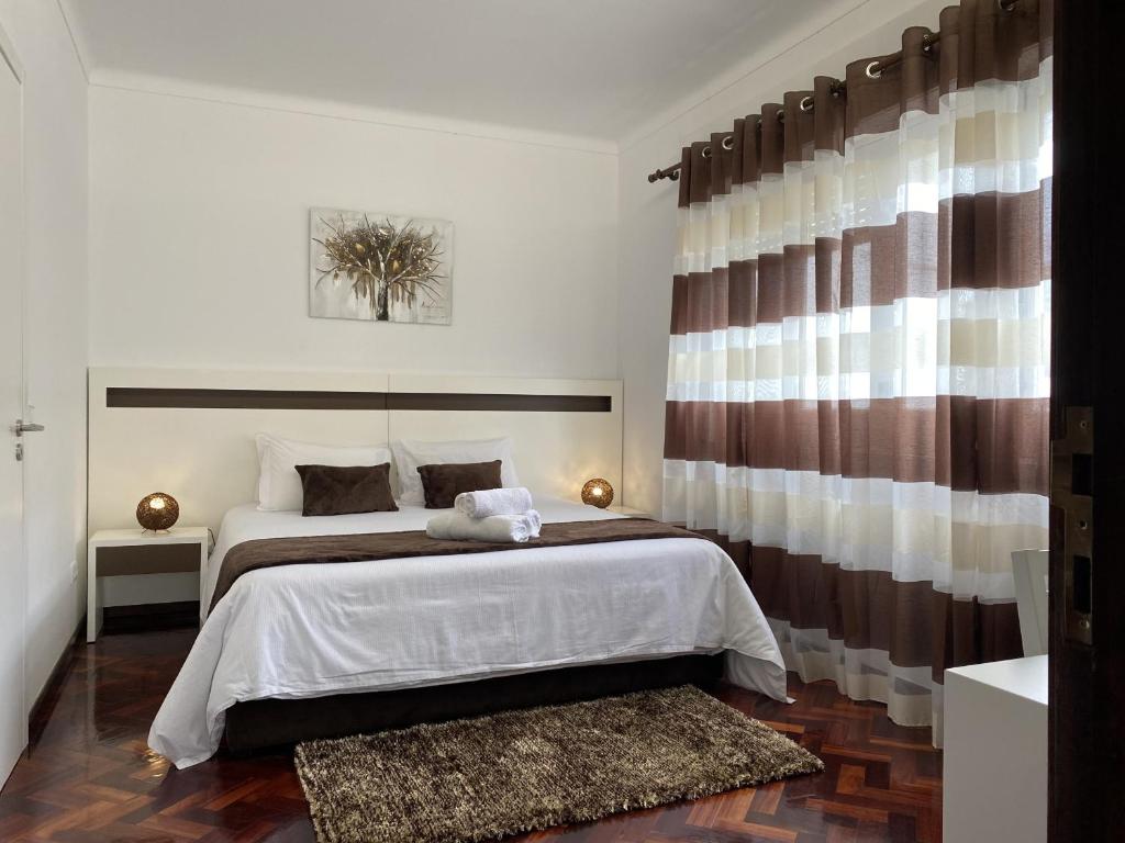 Un dormitorio con una cama grande y una ventana en The Rock Guest House, en Ponta Delgada
