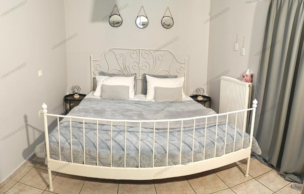 1 dormitorio con cama blanca y almohadas blancas en Georgias house 7 min from Athens airport, en Artemida