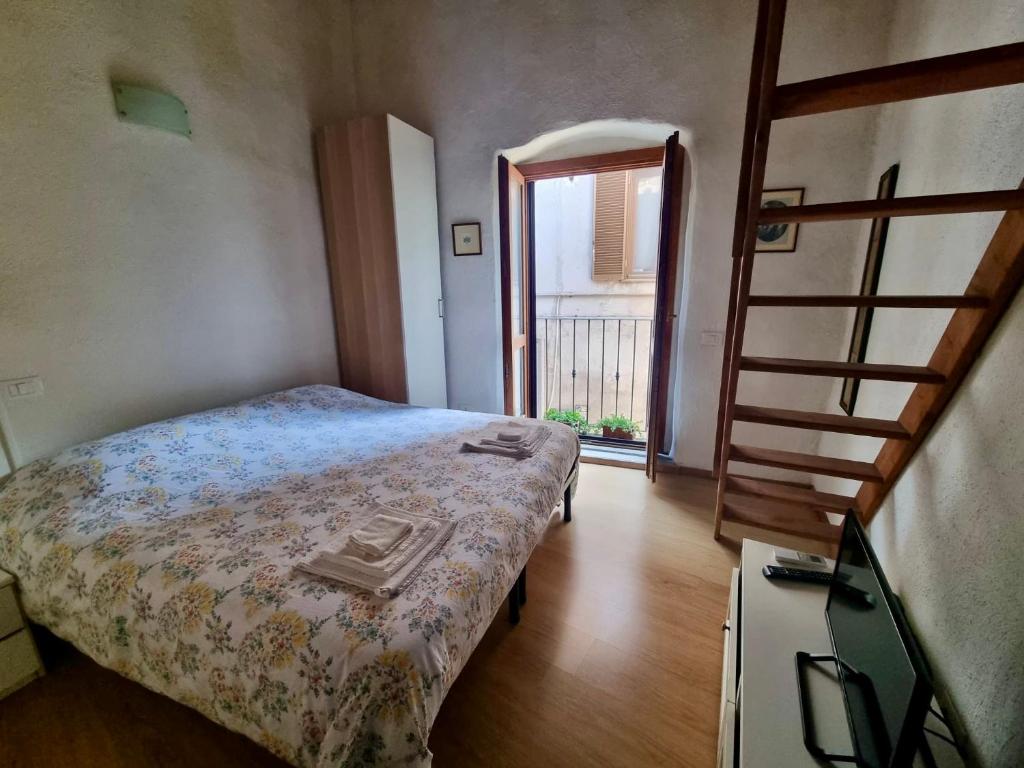 a small bedroom with a bed and a staircase at Francigena Maison in Sutri