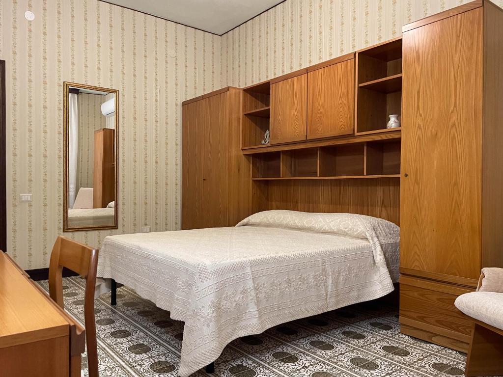 - une chambre avec un lit, une armoire et un miroir dans l'établissement Casa Doré in South Sardinia, à Sìnnai