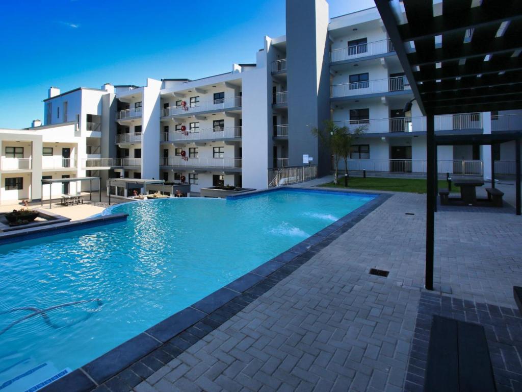 a swimming pool in front of a large apartment building at Nivica @ 4 in Langebaan