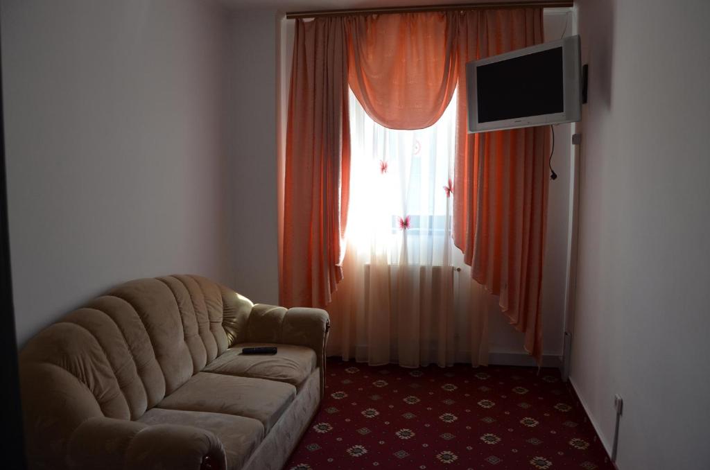 - un salon avec un canapé et une fenêtre dans l'établissement Коломия готель, à Kolomya