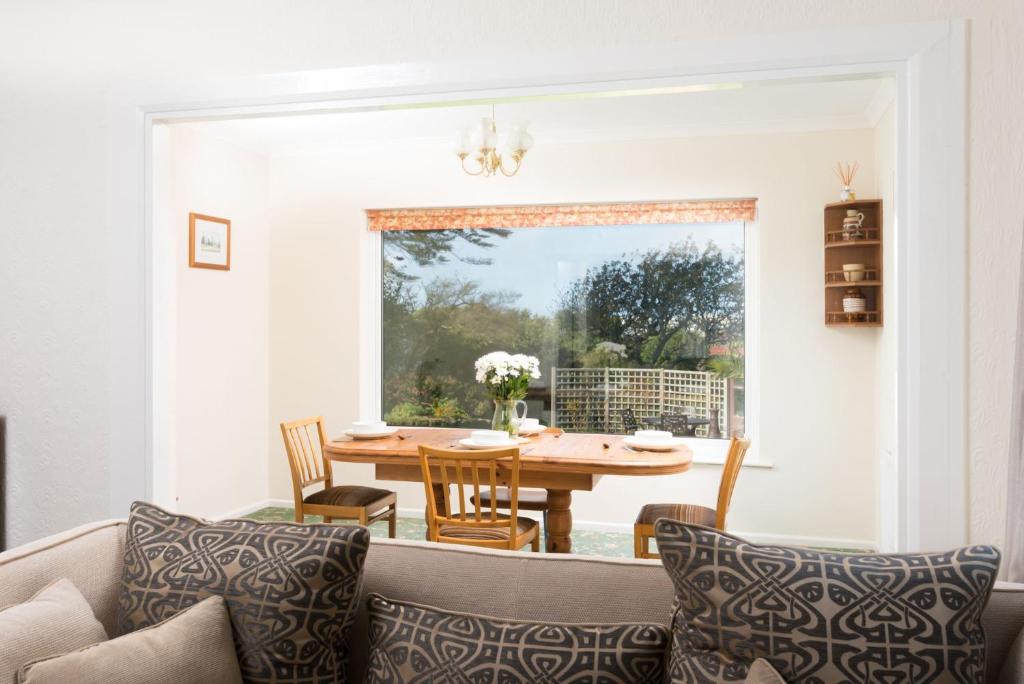 uma sala de estar com um sofá e uma mesa em Talland Croft em Crantock