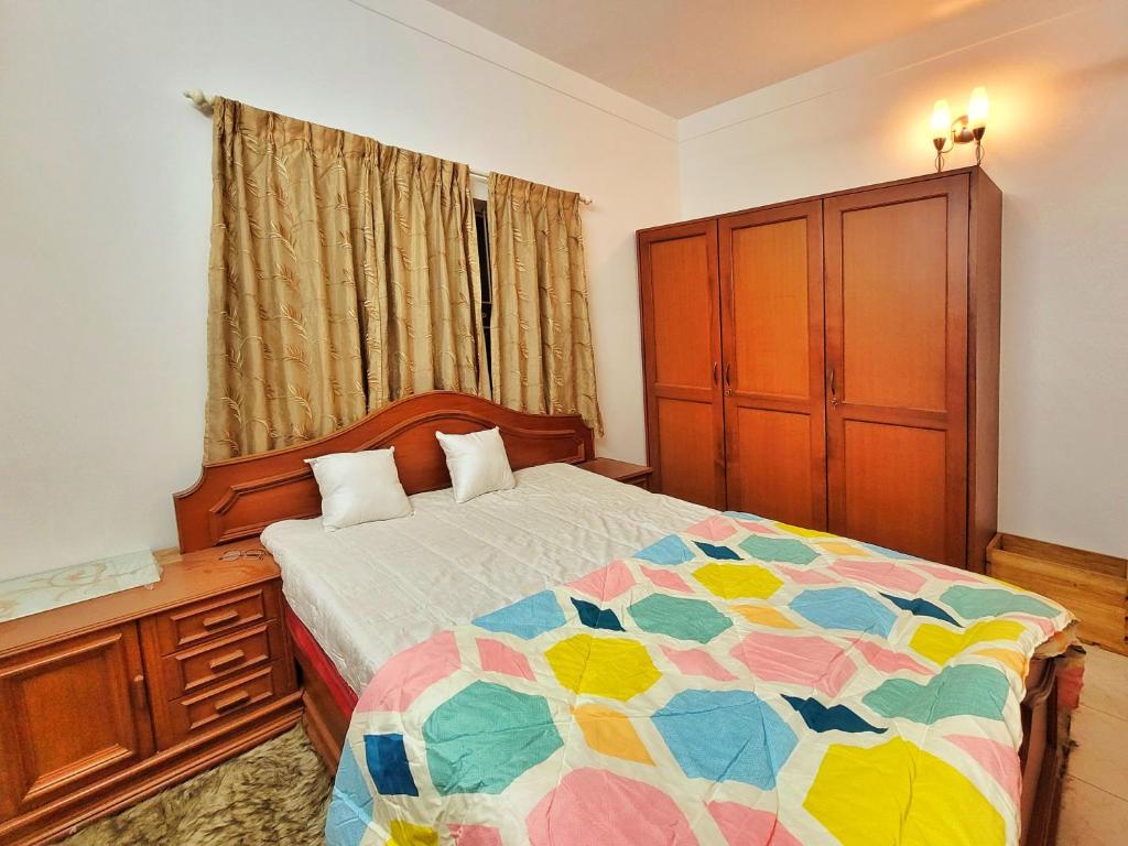 een slaapkamer met een bed met een kleurrijke quilt bij Willow - 2BHK in Bangalore