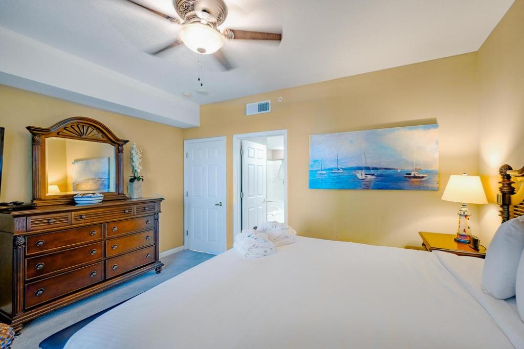 a bedroom with a bed and a dresser and a mirror at Legacy I 1008 in Gulfport