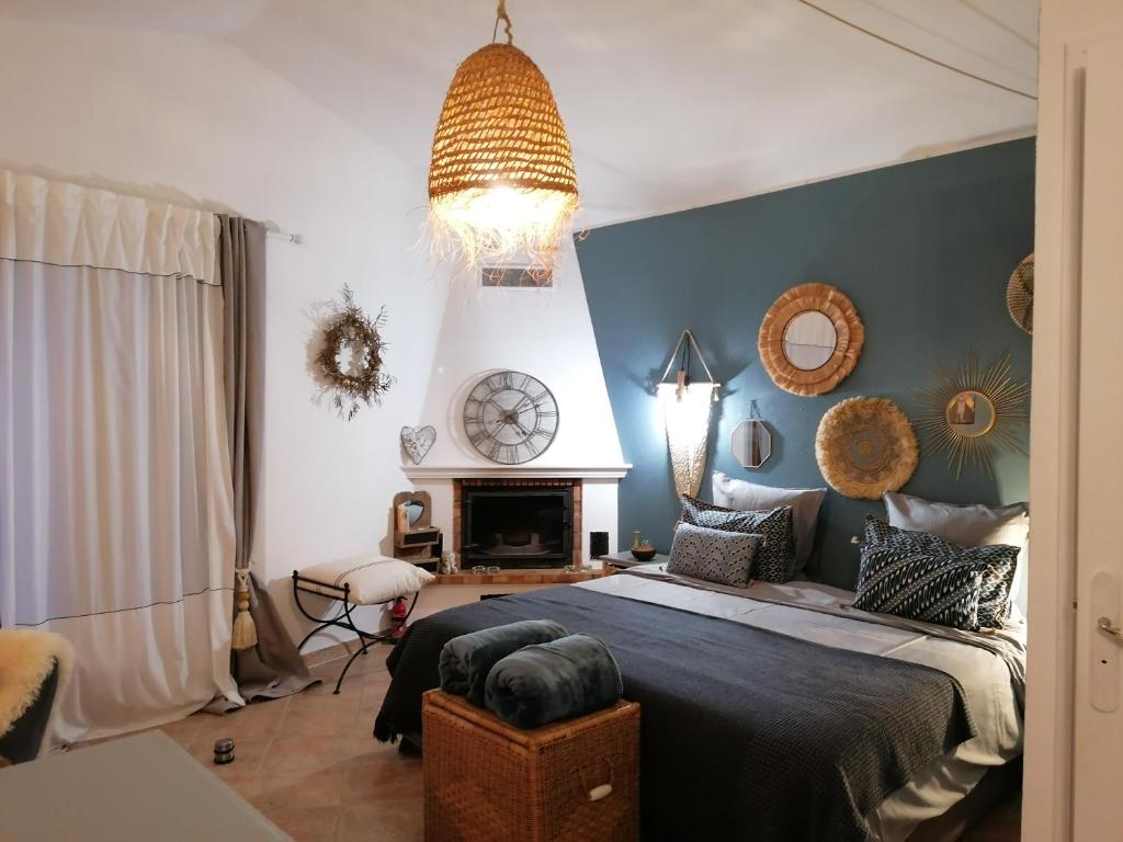 een slaapkamer met een groot bed en een open haard bij Studio au milieu d une oliveraie Le Mas de la huppe in Tourrettes-sur-Loup