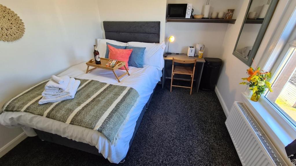 a small bedroom with a bed and a desk at Moorfield House in Banbury