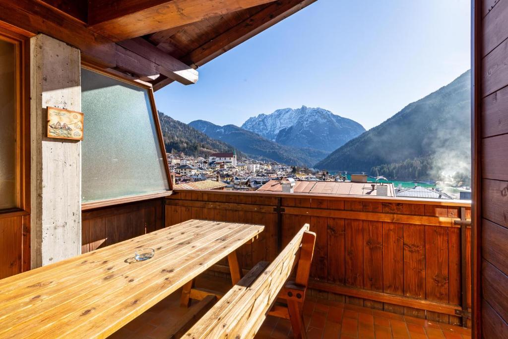 balcón con mesa de madera y vistas a la ciudad en Villa Pais 3 cime View en Auronzo di Cadore