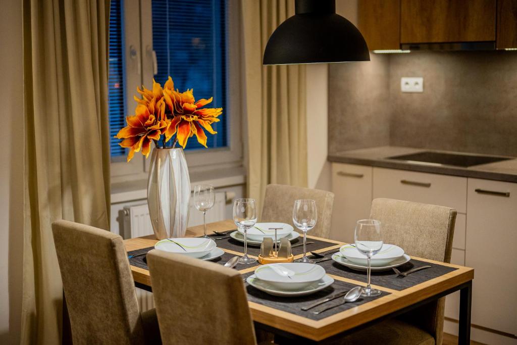 a dining room table with a vase of flowers on it at Old Town city center apartment 1 - private parking included in Košice