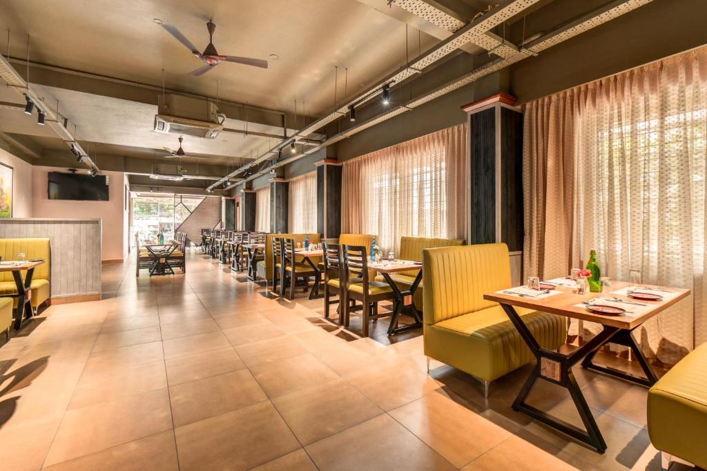 une salle à manger avec des tables et des chaises jaunes dans l'établissement HARI GOVINDA'S, à Mysore