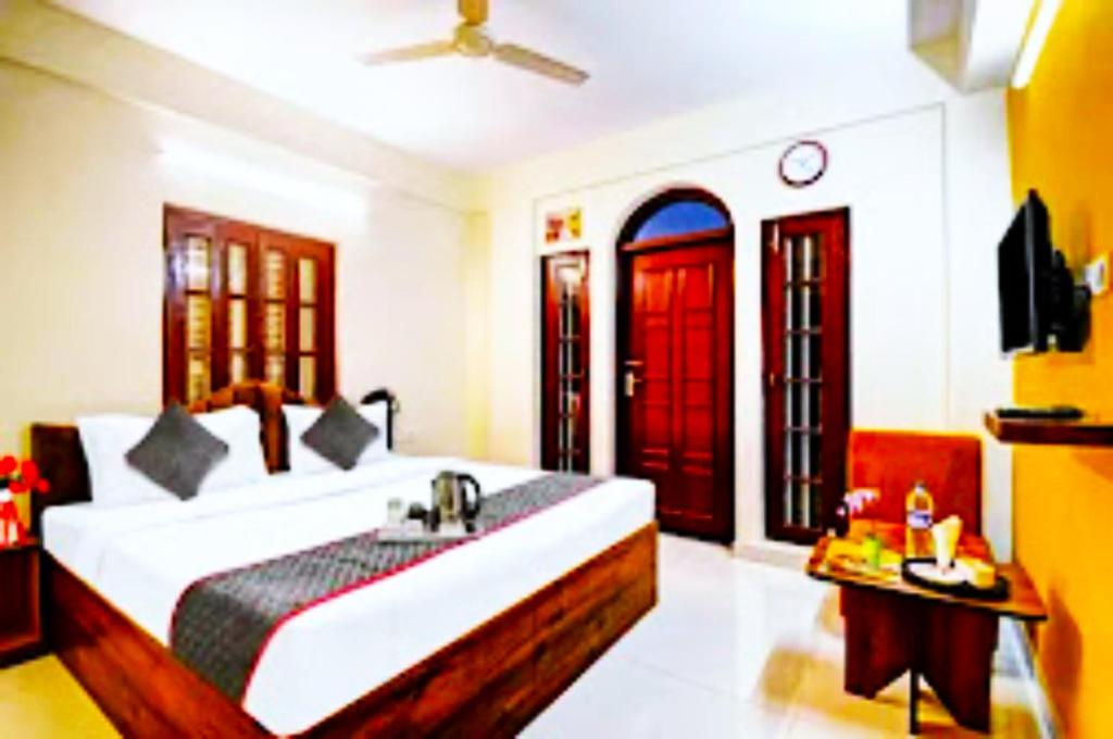 a bedroom with a bed with a sink and red doors at Hotel Jheel Mahal New Town Inn West Bengal - Couple Friendly in Jojera