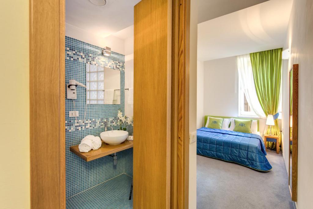 a bathroom with a sink and a bed in a room at Residenza Romantica in Rome