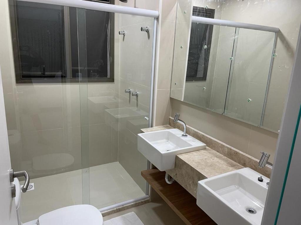 uma casa de banho branca com 2 lavatórios e um chuveiro em Refúgio em Condomínio- Flecheiras em Trairi
