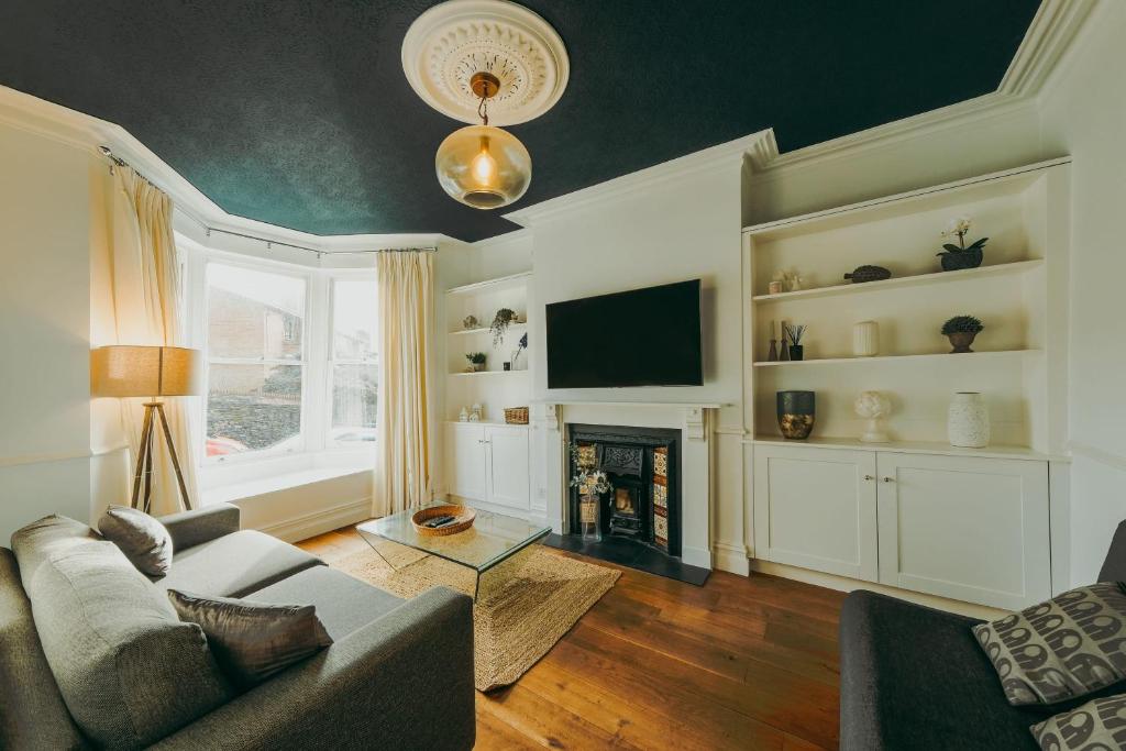 uma sala de estar com um sofá e uma lareira em St Vincent 3 bedroom property em Bristol