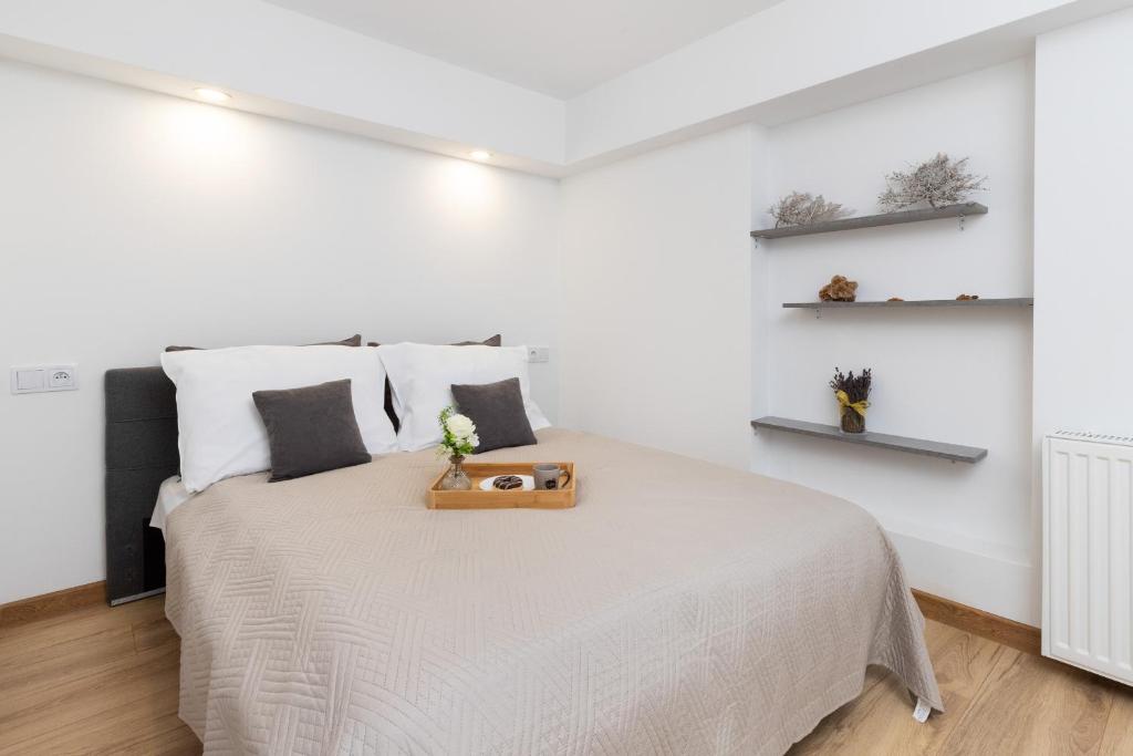 ein weißes Schlafzimmer mit einem Bett und einem Tablett darauf in der Unterkunft Beautiful Apartments in a Quiet Area of Gdynia by Renters in Gdynia