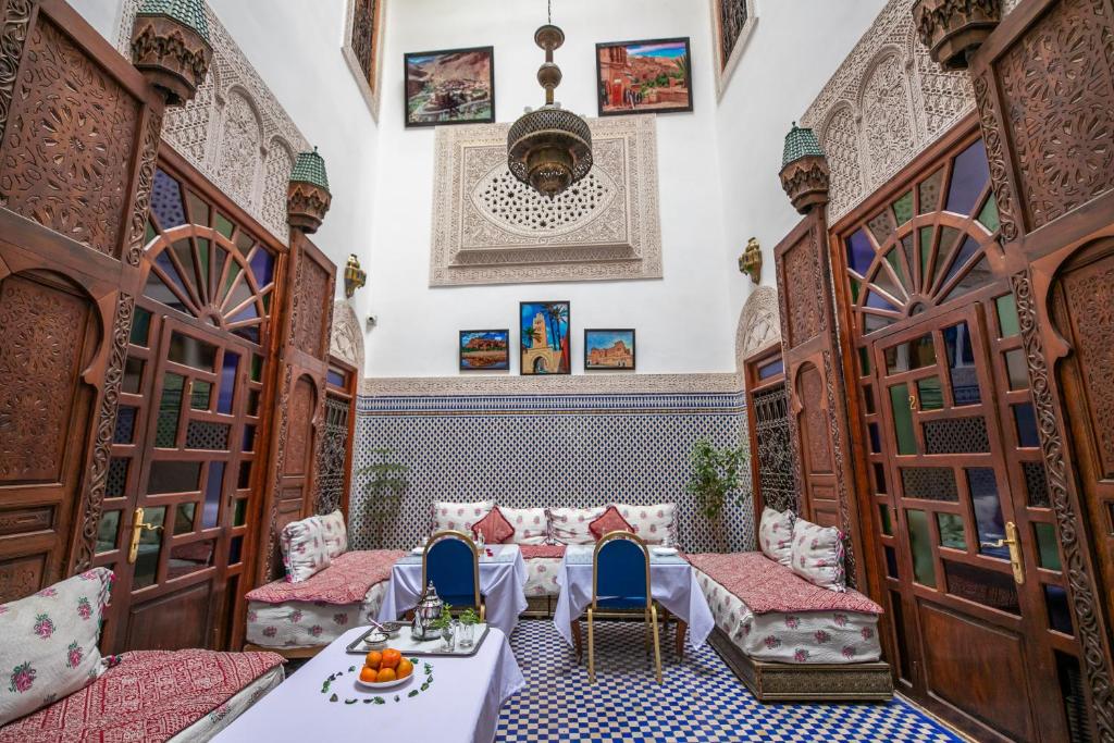 a room with two beds and a table and chairs at Riad Dar Rabha in Fez