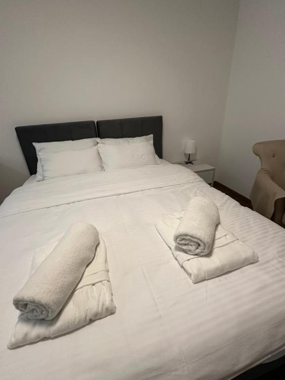 a large white bed with two towels on it at Vila Drina Apartments in Banja Koviljača