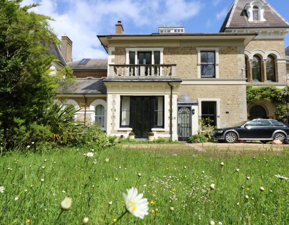 a house with a car parked in front of it at Grand Victorian family home - nestled between woodland and beach in Haven Street